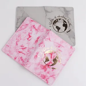 Detailed close-up of marble texture passport holder with travel globe print and leather feel.