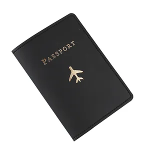 Dettaglio copripassaporto in pelle PU nera con testo goffrato dorato e motivo aereo.