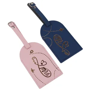 Primo piano dettaglio di etichette valigia in pelle rosa e blu con stampa mr e mrs.