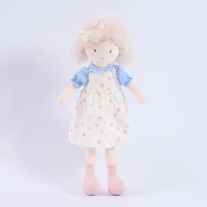Plush doll detail view, cute girl toy with soft pink hair and dress, delicate stitching.