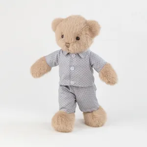 Close-up of a cute brown plush teddy bear wearing grey polka dot pajama set detail.