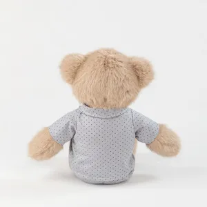 Close-up detail view of the brown plush teddy bear wearing a cute grey dotted pajama shirt.