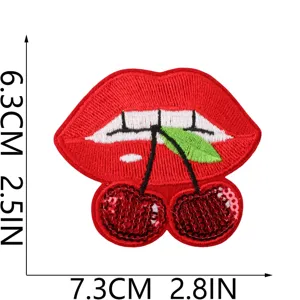 Gros plan détaillé du patch de broderie de lèvres à sequins rouges avec un motif de cerise.
