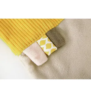 Coperta di sicurezza in morbido peluche per neonati con etichette tattili e colorate.