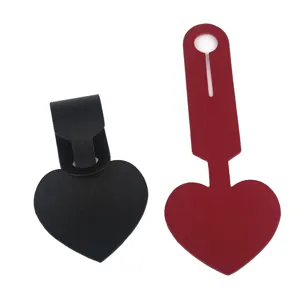 Close up of heart shaped PU leather luggage tag set in black and red for travel bags.