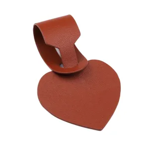Close-up detail of the brown heart-shaped PU leather luggage tag with hanging strap texture.