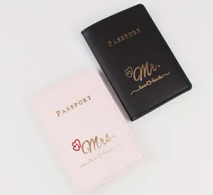 Detailansicht von schwarzen und rosa PU-Leder-Paar-Reisepasshüllen mit goldener Schrift.