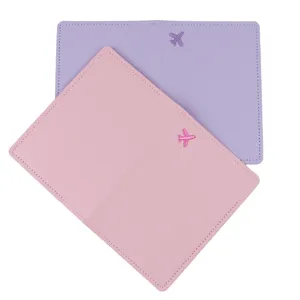 Gros plan détail de l'étui de passeport en cuir PU doux avec broderie d'avion mignonne.