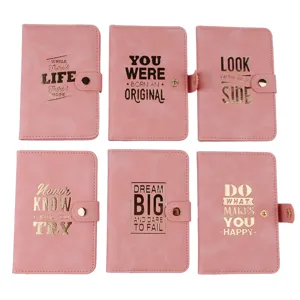 Detail view of pink PU leather passport holder featuring gold foil motivational quotes.