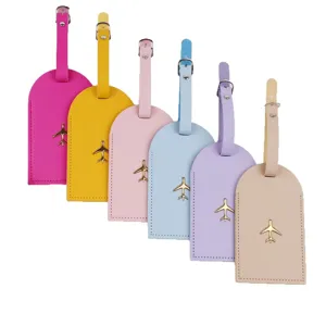 Set di etichette per valigie in pelle colorata con ciondoli in metallo aereo per viaggi.