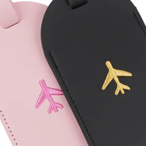 Detailed view of PU leather luggage tags featuring neat airplane embroidery in pink and black.