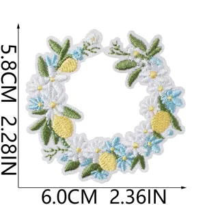 Detail shot of embroidered lemon and floral wreath patch showing size and craftsmanship.