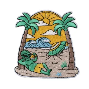Embroidered patch featuring a funny alien relaxing on a beach with palm trees and UFO.