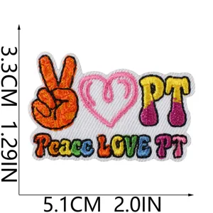 Close-up detail of colorful embroidered PT letter and peace heart patch with dimension guide.