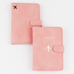 Closeup view of pink passport holder featuring gold foil airplane detail and card slots.