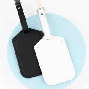 Detailed view of black and white cross-pattern leather luggage tags with adjustable straps.