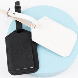 Close-up of black and white crosshatch leather luggage tags set with secure strap and metal buckle.