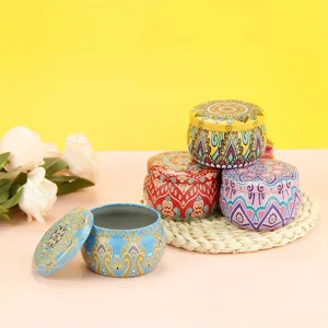 Detailed view of colorful mandala pattern tin cans arranged on straw mat with floral decor.