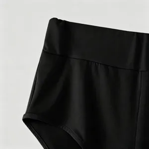 Primo piano dettaglio di pantaloncini da fitness neri a vita alta, cintura elastica.