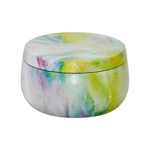 Close-up detail of the 170ml round metal tin featuring a colorful watercolor abstract pattern.