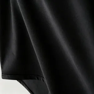 Primo piano del tessuto dei pantaloncini sportivi neri, con trama fine e cuciture robuste.