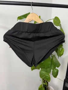 Vista dettagliata di pantaloncini sportivi neri a vita alta, cintura elastica, fitnesswear.