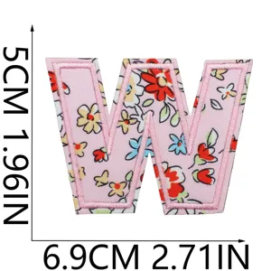 Vista dettagliata della toppa ricamata con lettera W a fiori rosa, ideale per abiti.
