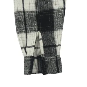 Close-up detail shot of a classic black and white plaid men shirt cuff with single button.