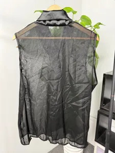 Details van de zwarte heren mesh mouwloze top met satijnen kraag en sexy clubwear stijl.