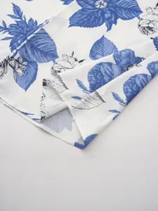 Detailed view of men's Hawaiian blue and white floral print shirt fabric, soft and breathable.