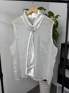 Gedetailleerd overzicht van witte heren mouwloze top met satijnen strikkraag en mesh.