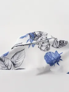 Close-up detail of blue and white floral print short sleeve shirt fabric and lapel design.