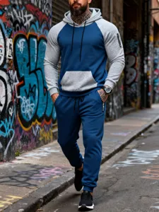 Urban street style detail shot of men's color-block fleece hoodie and joggers tracksuit set.
