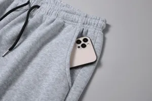Primo piano dettaglio di pantaloni della tuta felpati grigi tasca e coulisse uomo.