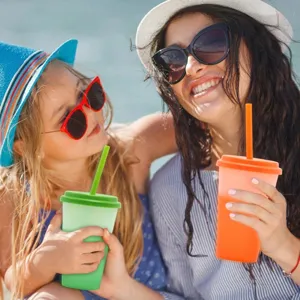 Famiglia felice che usa bicchieri che cambiano colore con cannuccia all'aperto