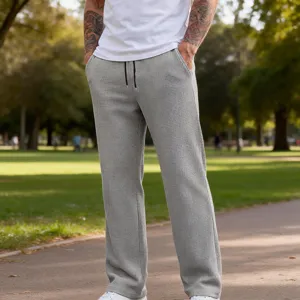 Vista dettagliata dei pantaloni casual da uomo grigi chiari in tessuto waffle con coulisse.