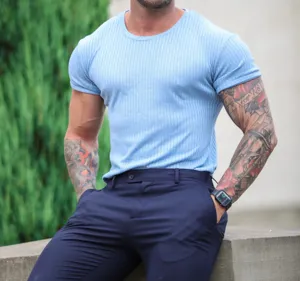 Close-up detail shot of a light blue ribbed short sleeve slim fit t-shirt worn by model.