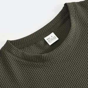 Nahaufnahme des dunkelgrünen strukturierten Kurzarm-T-Shirt-Kragens mit Stoff und Etikett.