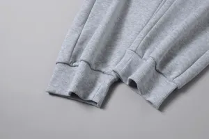 Dettaglio polsino pantaloni felpati grigi da uomo, tessuto morbido primo piano.