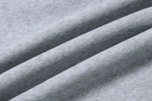 Dettaglio tessuto felpato grigio, consistenza morbida per pantaloni tuta casual.