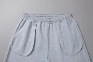 Dettaglio pantaloni tuta felpati uomo, vista vita e tasche sport grigi casual.