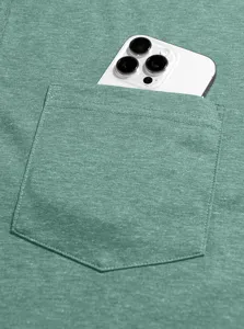 Close-up detail of sage green mens t-shirt chest pocket holding a white smartphone