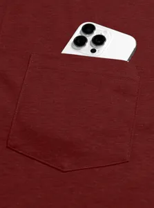 Close-up detail of a mens burgundy t-shirt chest pocket with a smartphone inside.