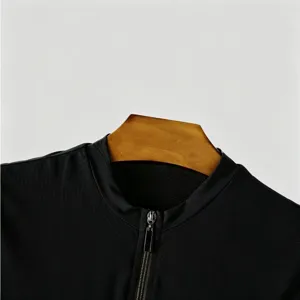 Black mens knit short sleeve detail, zipper collar close-up view, stretchy fabric texture.