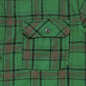 Detailed shot of green plaid flannel shirt chest pocket texture, vintage men casual style.