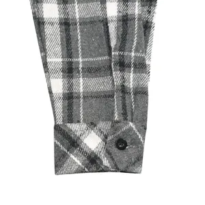 Detailed view of the cuff on a casual plaid flannel shirt, featuring classic patterns.