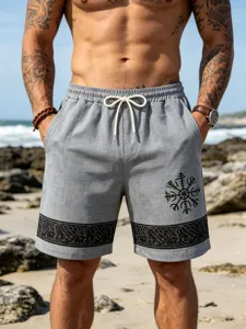 Close-up detail of grey linen-blend men's beach shorts featuring Viking totem print and hem band.