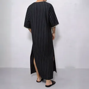 Detail view of men's striped traditional long thobe robe with side slits and braided cuffs.