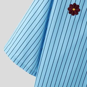 Nahaufnahme eines hellblauen Herren-Kurzarmhemds mit Streifen und roter Blumen-Bestickung.