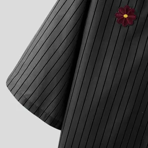 Nahaufnahme der Details von Herren vertikal gestreiften Kurzarmhemd mit feiner Blumenstickerei.